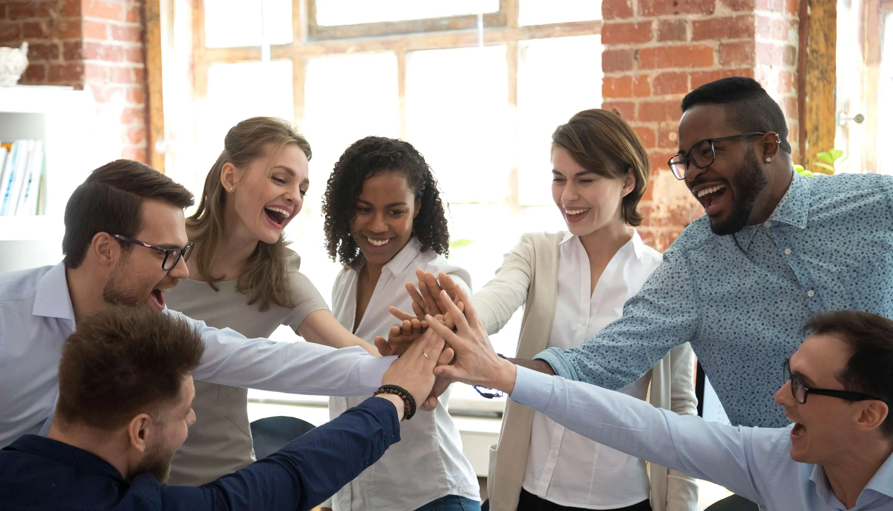 Team joining hands in celebration