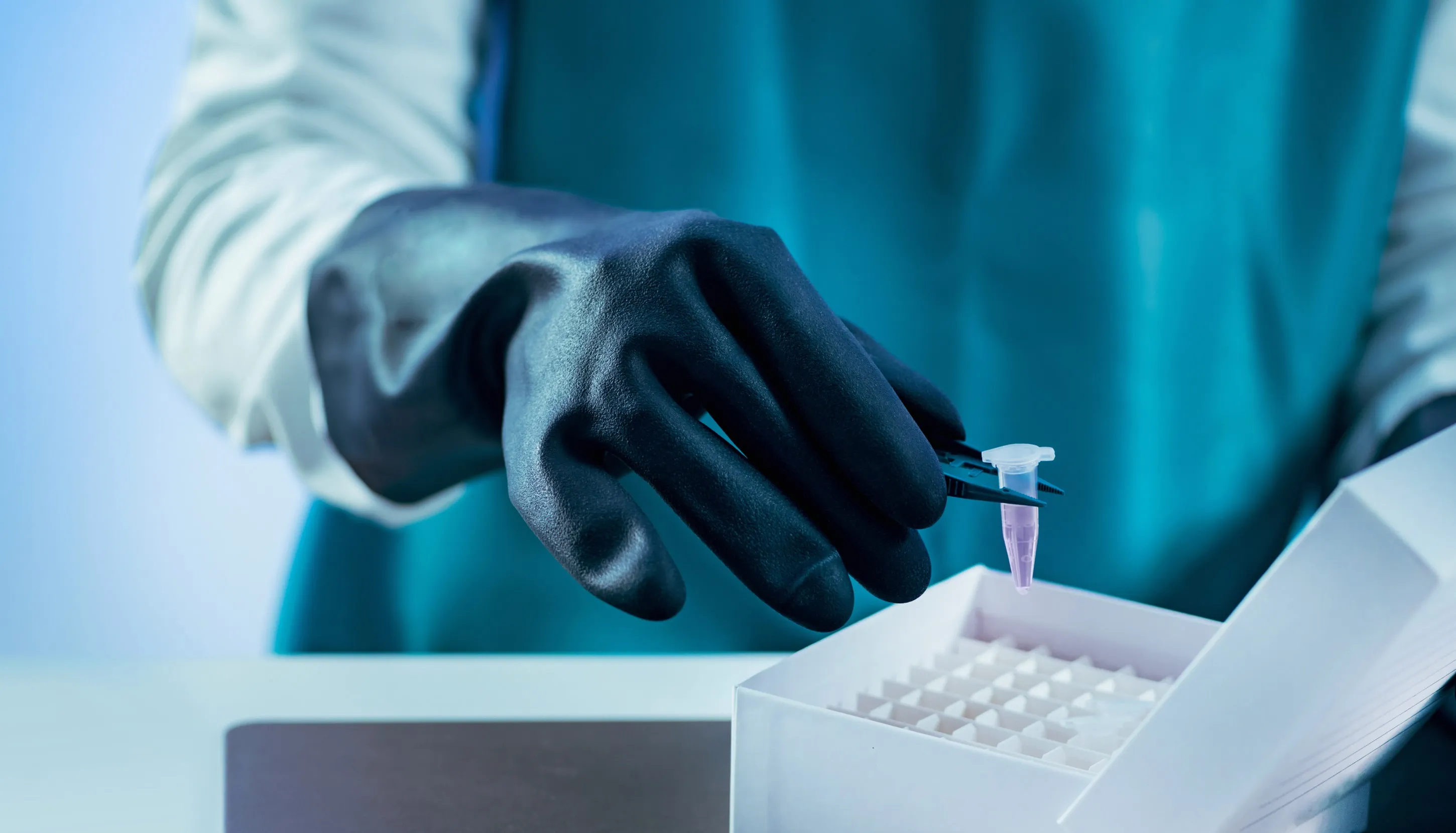 Hand holding a small pipette, putting in a box