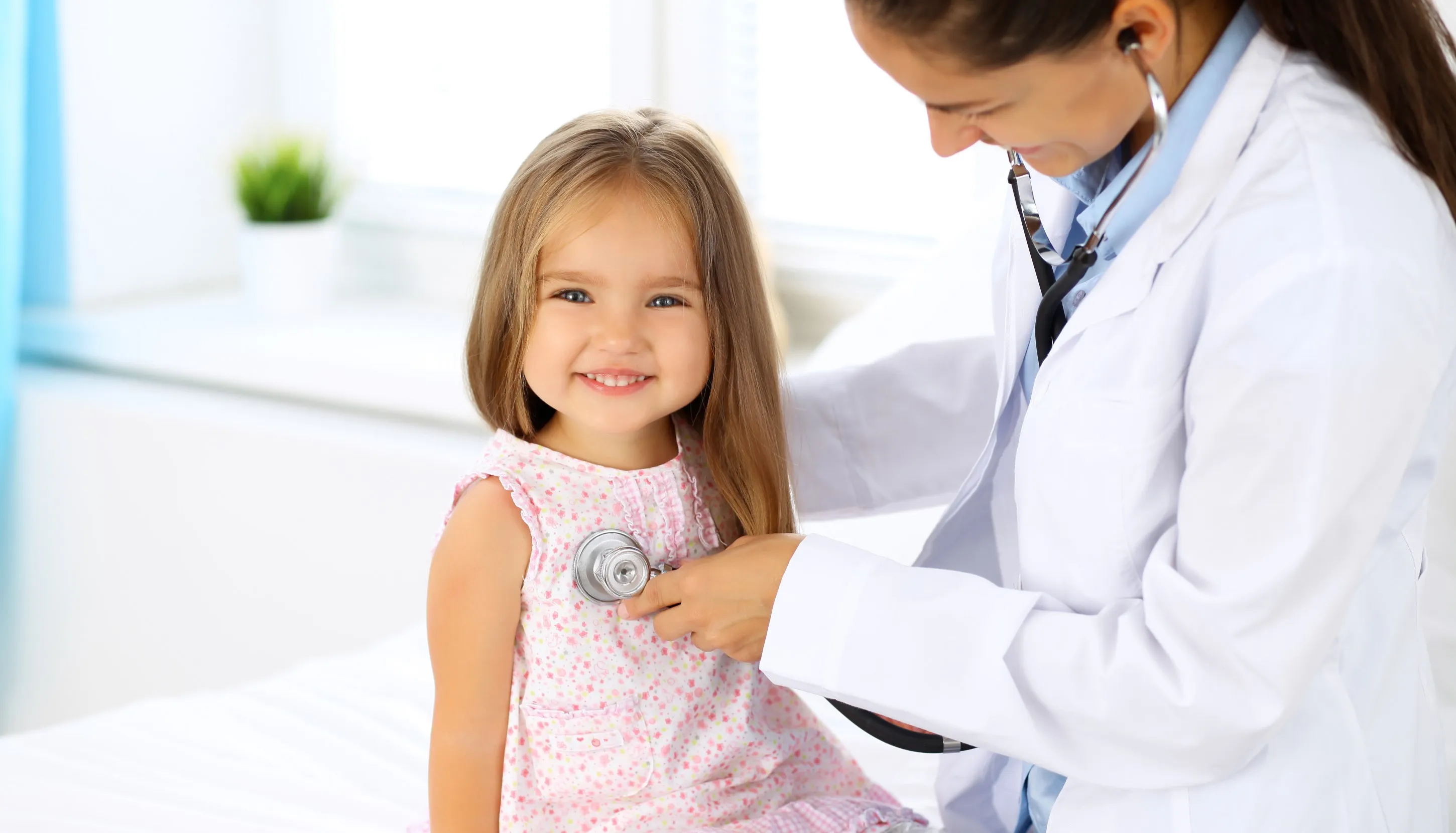 Smiling child gets checked by a doctor