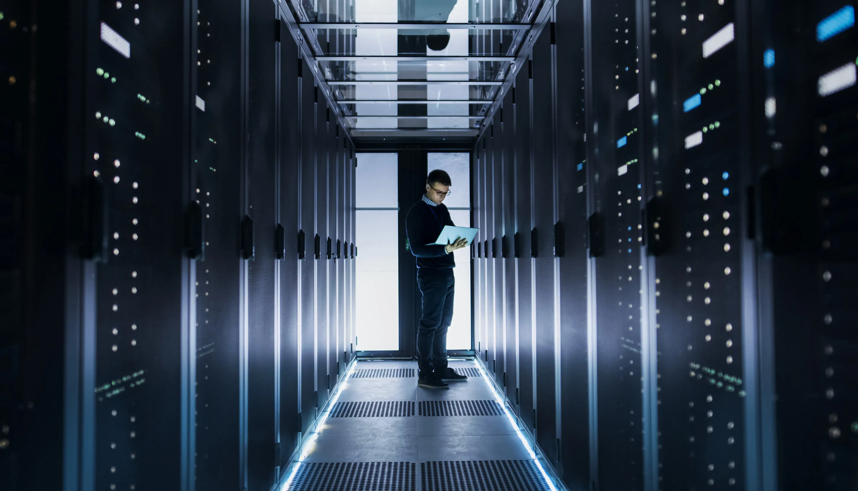 Employee looking at his tablet in server room