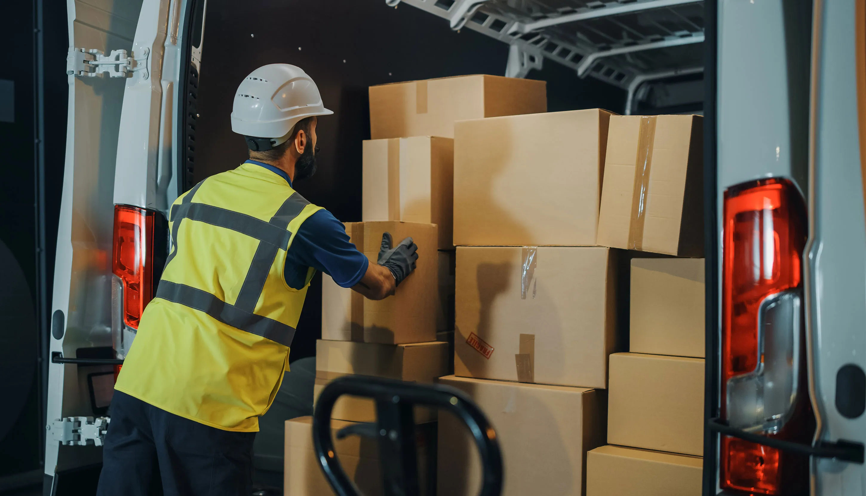 Delivery worker packing boxes into a delivery truck