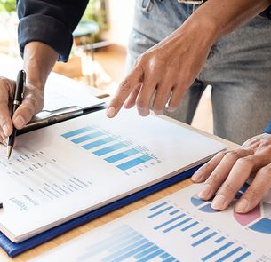People looking at the chart while writing something down People looking at the chart while writing something down