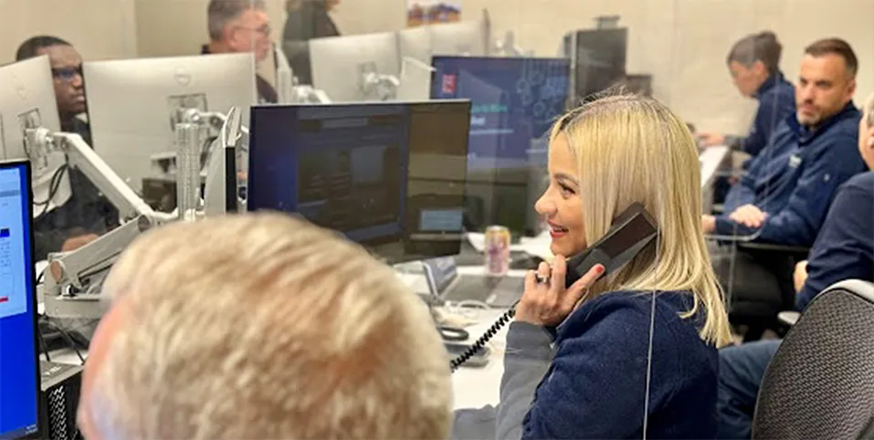 Employee talking on the phone while looking at the monitor in office